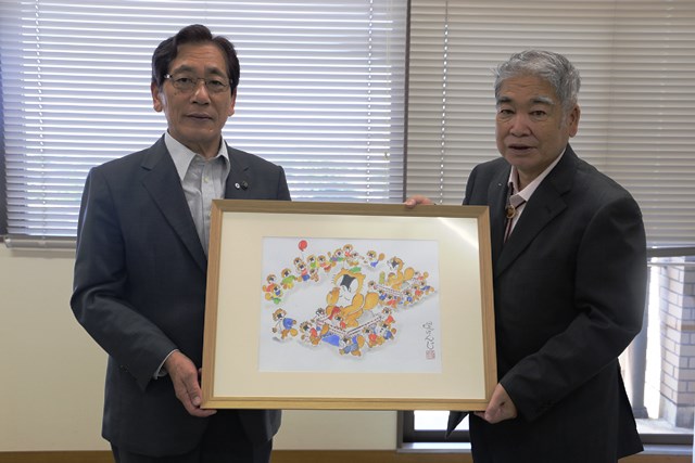 松本市長（左）に絵を手渡す堤さん