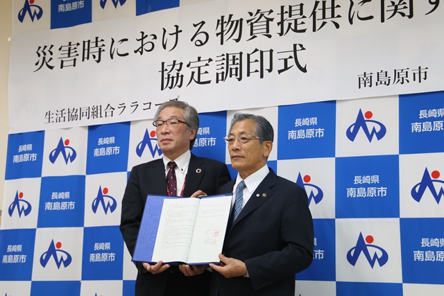 協定書を手に記念撮影する様子（左から石原理事長、松本市長）