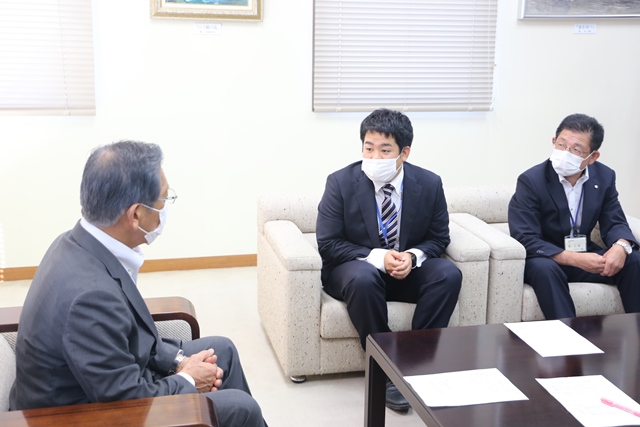 松本市長（左）と談話する佐藤主事（中央）