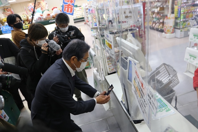 松本市長が実際にミナコインアプリで買い物する様子。スマホで店舗の2次元コード読み取り中
