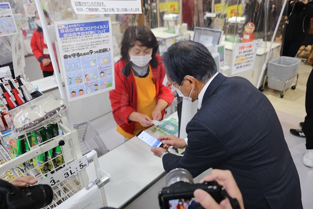 松本市長が買い物金額を入力し、店員さんが金額確認中の様子