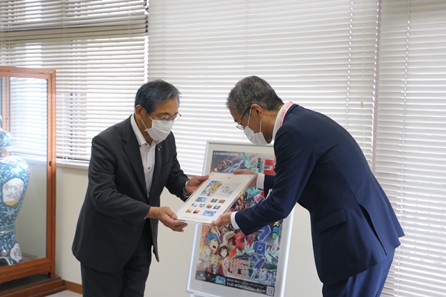 市長（左）に切手を贈呈する松田統括局長（右）