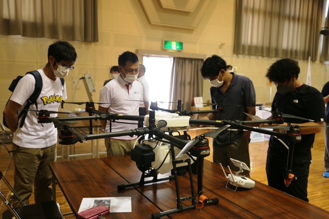 展示品の説明を受ける参加者 展示品の説明を受ける参加者